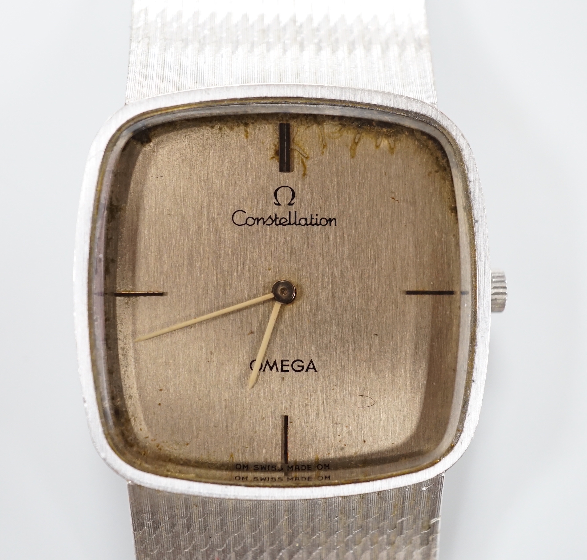 A gentleman's 1970's 750 white metal Omega Constellation manual wind dress wrist watch, on integral 750 Omega bracelet, movement c.700, with part paperwork, overall 18.3cm, gross weight 75.1 grams.